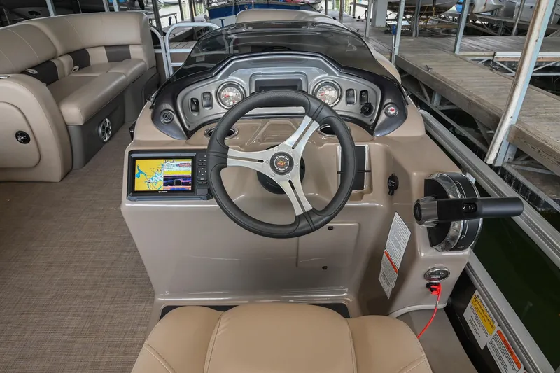 Slide: The Image of 2023 SUNTRACKER DLX 22 Sportfish boat dashboard with steering wheel and navigation display. - 15