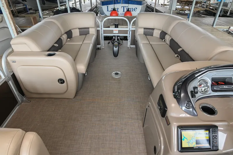 Slide: The Image of 2023 SUNTRACKER DLX 22 Sportfish interior with beige seating and modern dashboard. - 19
