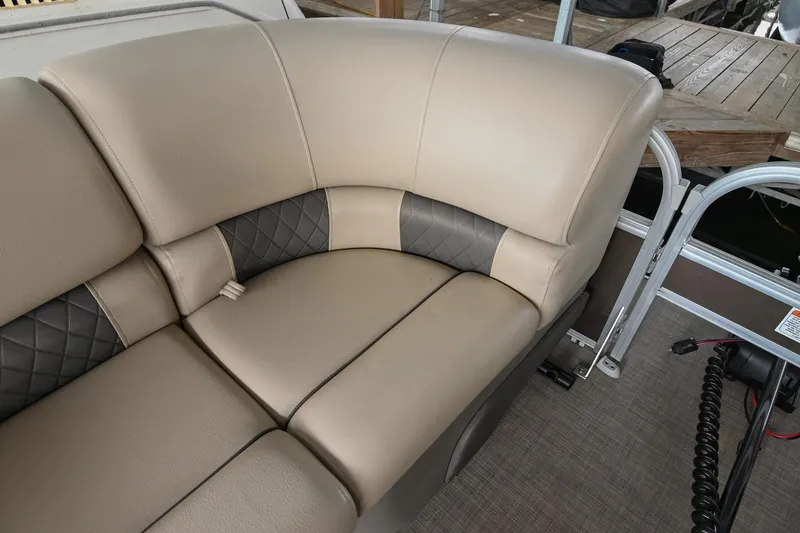 Slide: The Image of 2023 SUNTRACKER DLX 22 Sportfish boat seating with beige and gray upholstery. - 22
