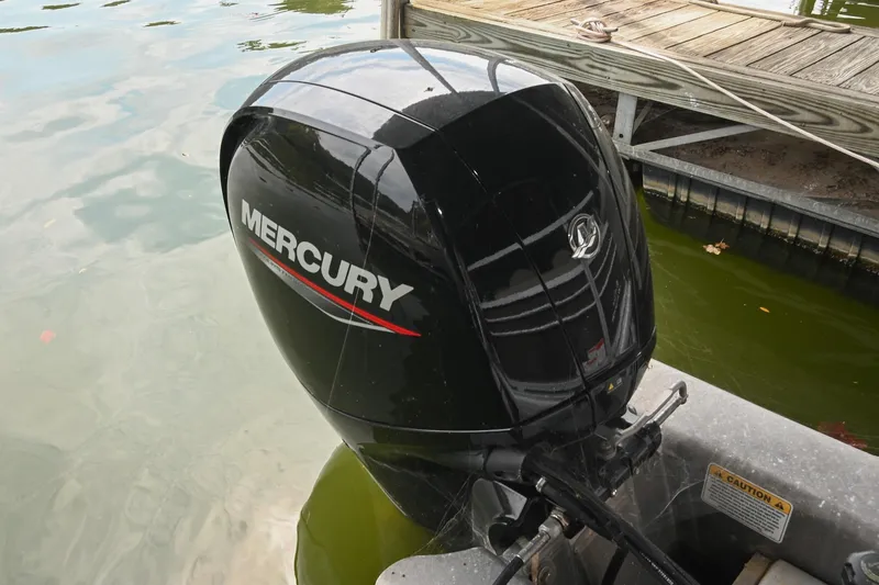 Slide: The Image of Mercury outboard motor on 2023 SUNTRACKER DLX 22 Sportfish, docked by wooden pier. - 6