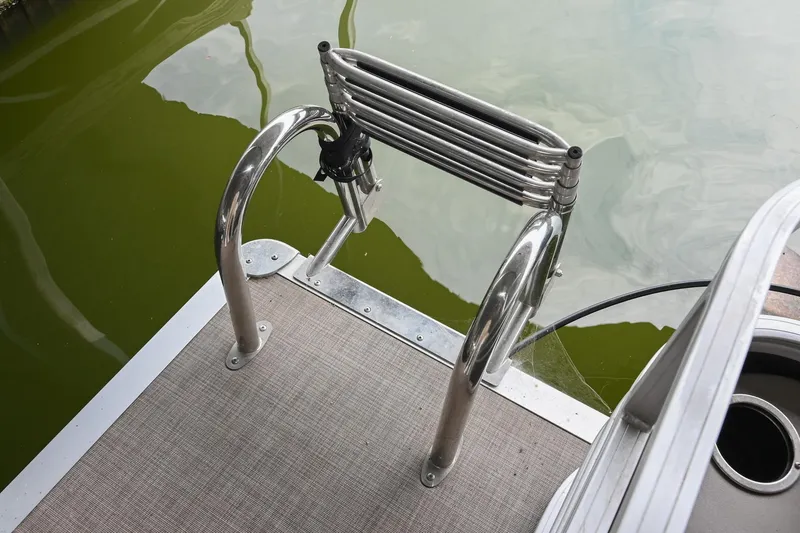 Slide: The Image of 2023 SUNTRACKER DLX 22 Sportfish boat ladder on water. - 7