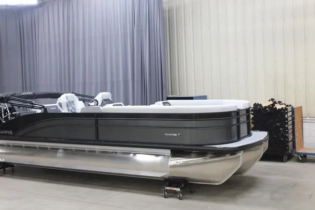 The Image of 2026 Harris Cruiser 250 pontoon boat in a showroom setting. - 1