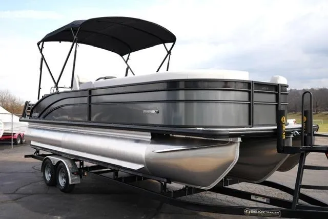 Slide: The Image of 2026 Harris Cruiser 250 pontoon boat on trailer with canopy, parked outdoors. - 5