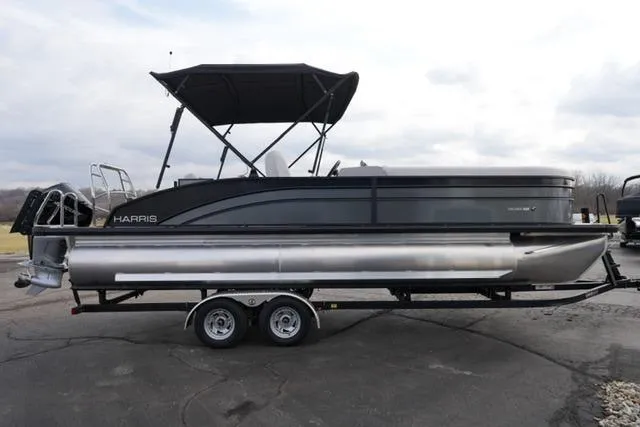 Slide: The Image of 2026 Harris Cruiser 250 pontoon boat on trailer, featuring sleek design and canopy. - 6