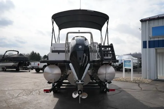 Slide: The Image of 2026 Harris Cruiser 250 pontoon boat on trailer, parked outdoors under cloudy sky. - 9