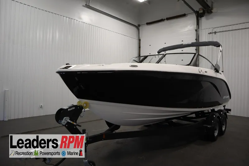 The Image of 2026 Yamaha Boats SX220 in showroom, black and white design, on trailer. - 0
