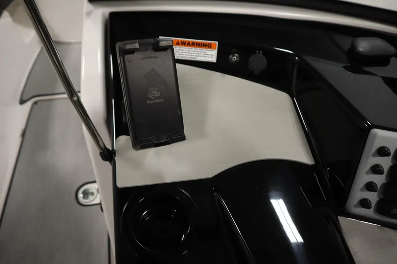 Slide: The Image of 2026 Yamaha Boats SX220 dashboard with phone holder and warning label. - 21