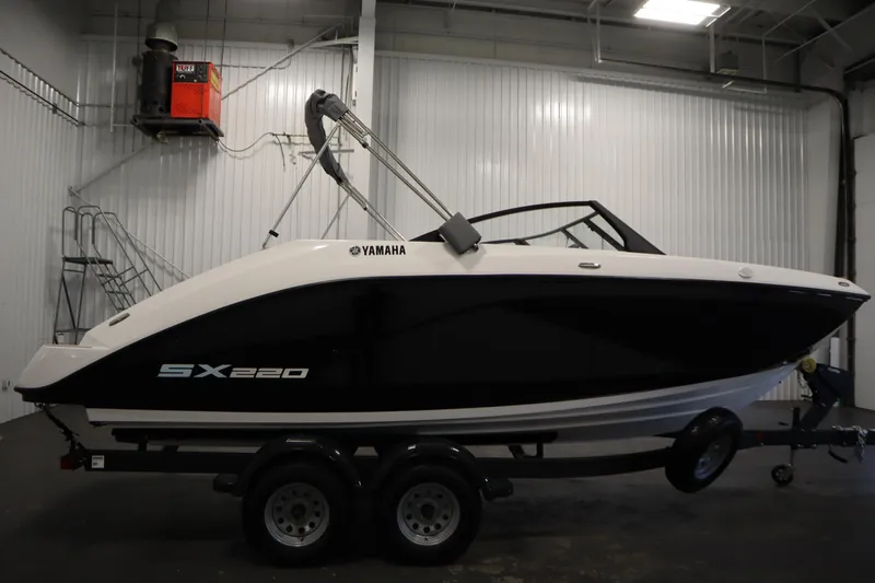 Slide: The Image of 2026 Yamaha Boats SX220 in a showroom, side view on a trailer. - 3