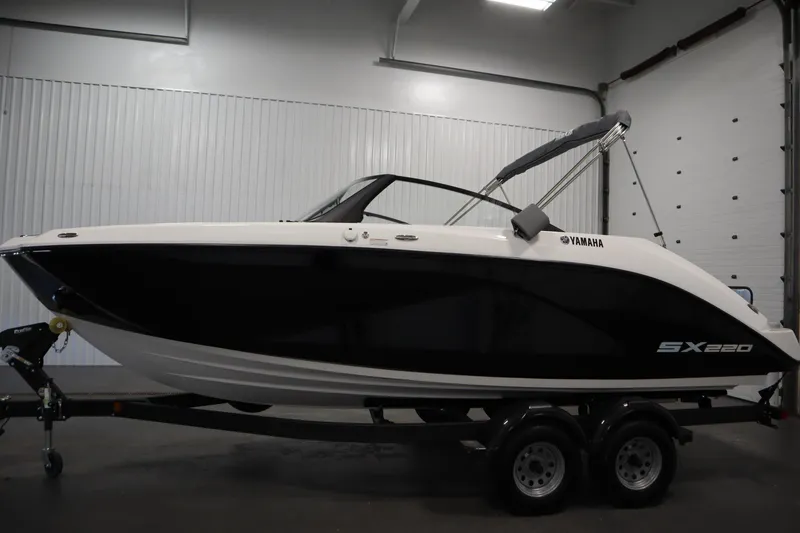 Slide: The Image of 2026 Yamaha Boats SX220 in a showroom, sleek design with black and white exterior. - 7