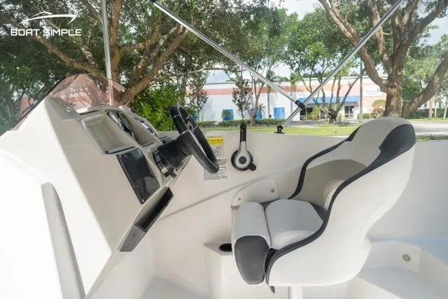 Slide: The Image of 2023 Starcraft SVX 231 OB DH boat interior with steering wheel and comfortable seating. - 14
