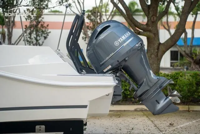 Slide: The Image of 2023 Starcraft SVX 231 OB DH boat with Yamaha outboard motor in a parking area. - 6