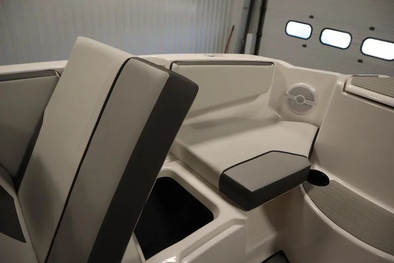 Slide: The Image of 2026 Yamaha Boats SX220 interior with spacious seating and modern design in a garage setting. - 14