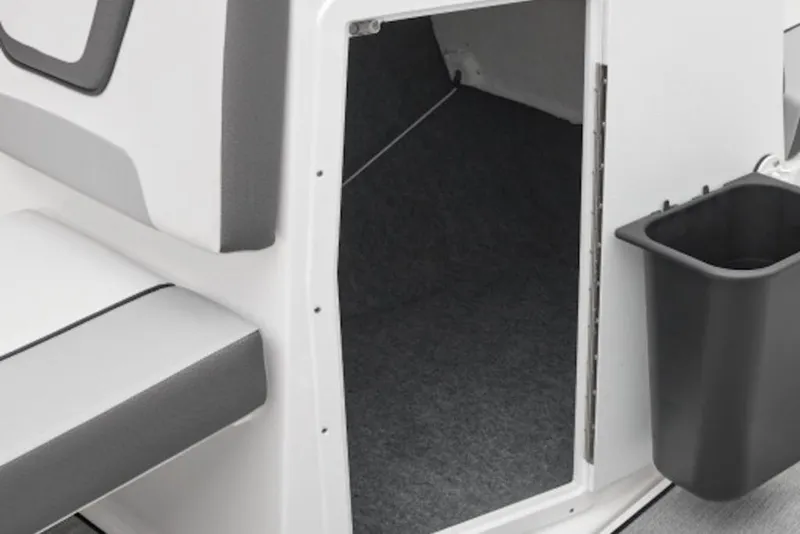 Slide: The Image of 2026 Yamaha Boats SX220 interior storage compartment with seating and trash bin. - 51