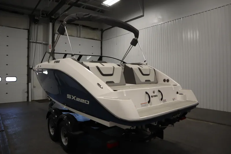 Slide: The Image of 2026 Yamaha Boats SX220 in a warehouse, rear view showcasing sleek design. - 6