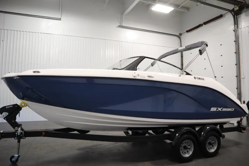 Slide: The Image of 2026 Yamaha Boats SX220 interior view in a garage, showcasing seating and helm. - 7