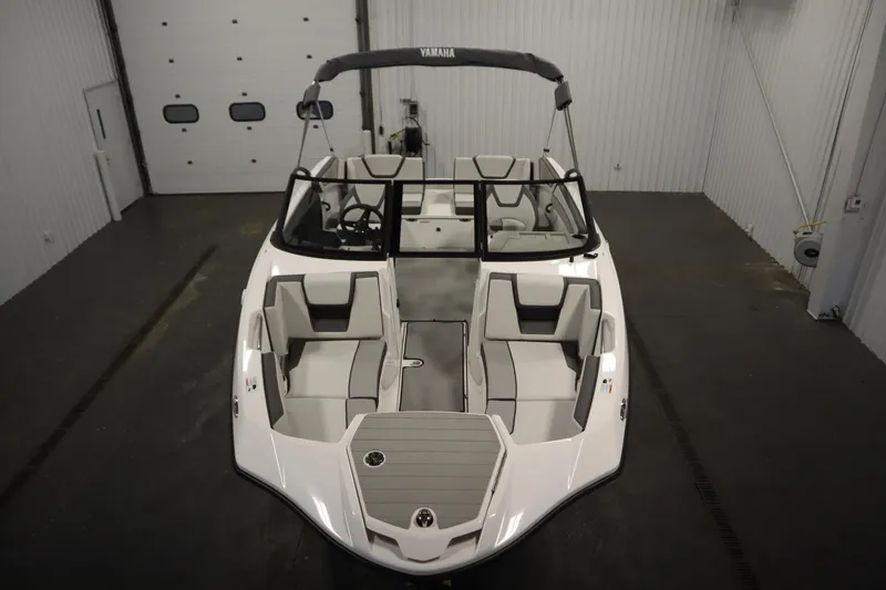 Slide: The Image of 2026 Yamaha Boats SX220, blue and white, on trailer in indoor setting. - 8