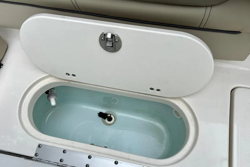 Slide: The Image of Open storage compartment on 2022 Key West 203 DFS boat, featuring a white lid and light blue interior. - 13
