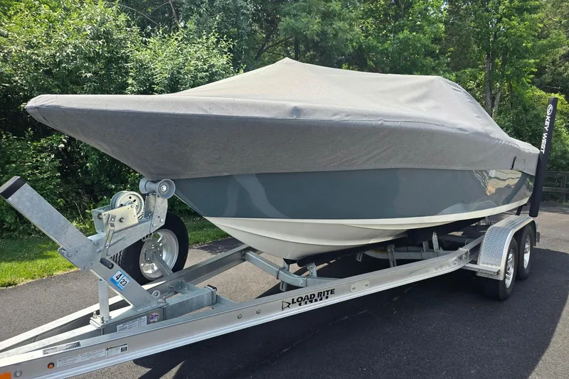 Slide: The Image of 2022 Key West 203 DFS boat covered on trailer, parked outdoors. - 2