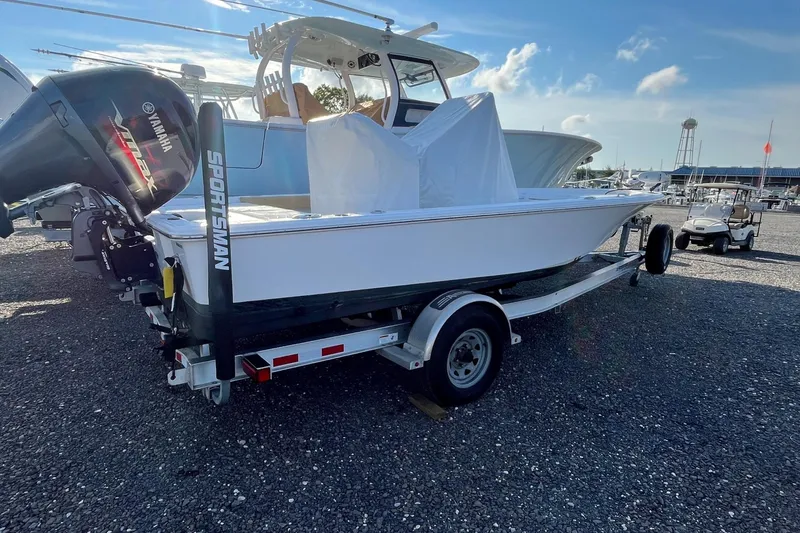 Slide: The Image of 2022 Sportsman Masters 207 Bay Boat on trailer, parked outdoors under clear sky. - 12