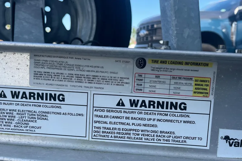 Slide: The Image of Warning labels and tire information on a 2022 Sportsman Masters 207 Bay Boat trailer. - 5