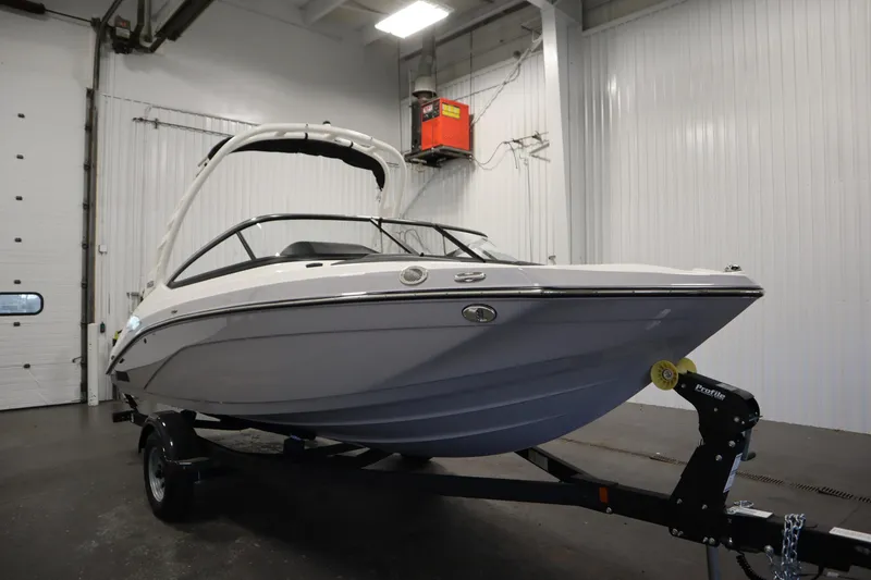 Slide: The Image of 2026 Yamaha Boats 195S in a showroom, sleek design on a trailer. - 2