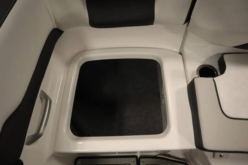 Slide: The Image of 2026 Yamaha Boats 195S interior storage compartment with sleek design and cup holder. - 37