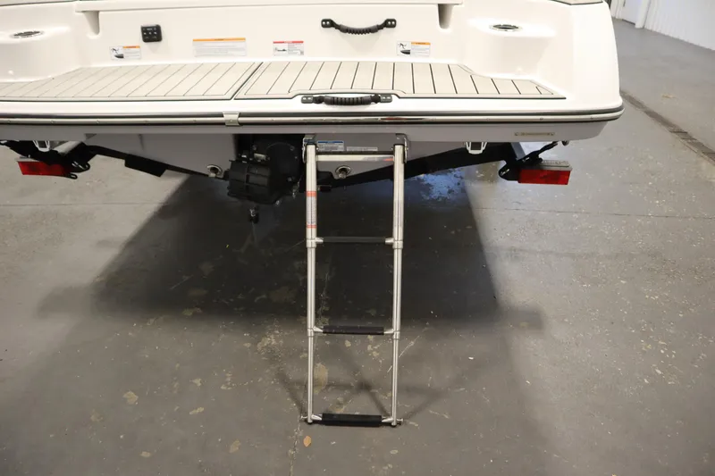 Slide: The Image of 2026 Yamaha Boats 195S with extended swim ladder on a concrete floor. - 42