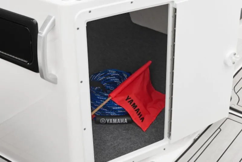 Slide: The Image of Open storage compartment on 2026 Yamaha Boats 195S with rope and red Yamaha flag. - 50