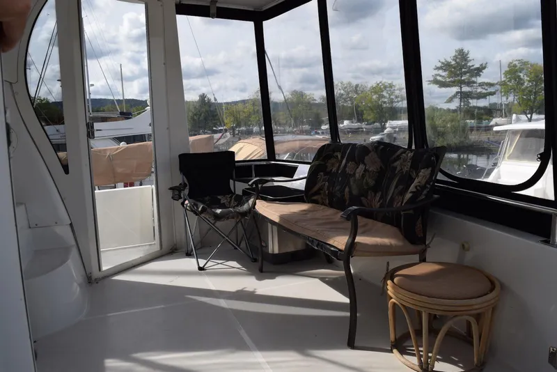 Slide: The Image of 2001 Carver 444 Cockpit Motor Yacht interior with seating, windows, and marina view. - 14