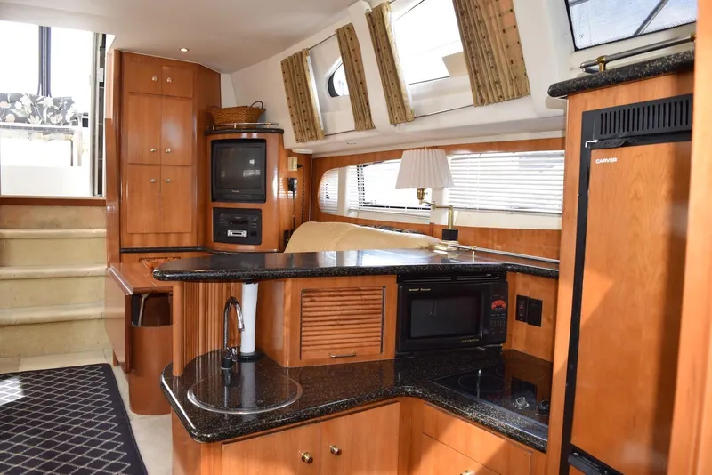 Slide: The Image of Interior of 2001 Carver 444 Cockpit Motor Yacht with modern kitchen and entertainment area. - 17