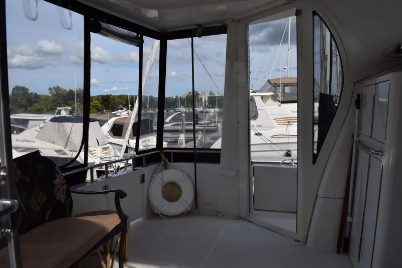 Slide: The Image of 2001 Carver 444 Cockpit Motor Yacht interior with marina view and seating area. - 8