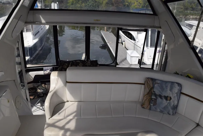 Slide: The Image of Interior of 2001 Carver 444 Cockpit Motor Yacht with white seating and marina view. - 9