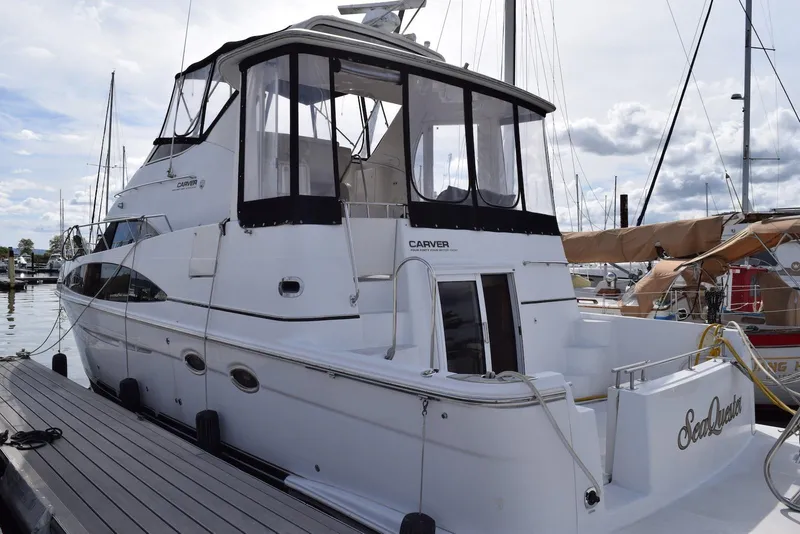 Slide: The Image of 2001 Carver 444 Cockpit Motor Yacht docked at marina, showcasing sleek design and spacious cockpit. - 2
