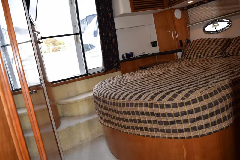 Slide: The Image of Interior of 2001 Carver 444 Cockpit Motor Yacht with cozy bedroom and checkered bedding. - 23