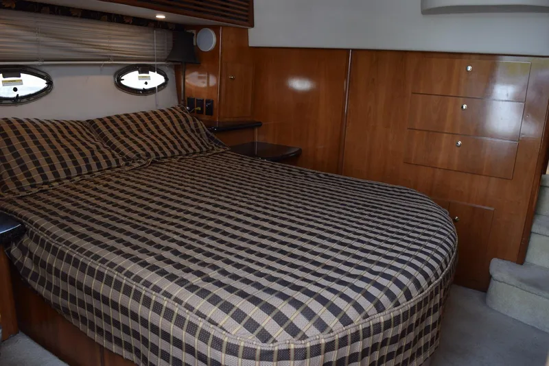 Slide: The Image of Luxurious bedroom interior of 2001 Carver 444 Cockpit Motor Yacht with checkered bedding. - 24