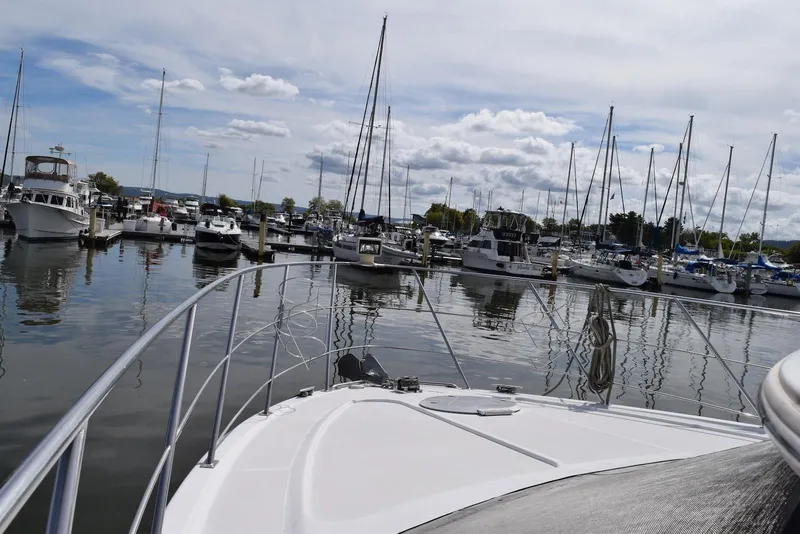 Slide: The Image of 2001 Carver 444 Cockpit Motor Yacht docked in a marina with sailboats and cloudy sky. - 4