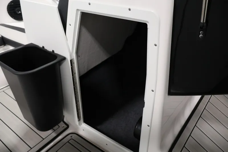 Slide: The Image of 2026 Yamaha Boats 195S storage compartment with sleek interior and adjacent trash bin. - 16
