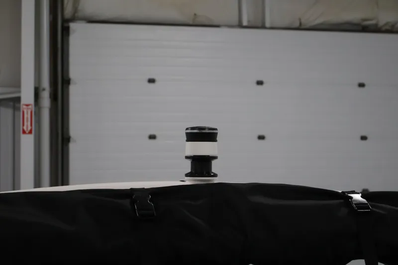 Slide: The Image of 2026 Yamaha Boats 195S with covered top and visible radar dome in a garage. - 33