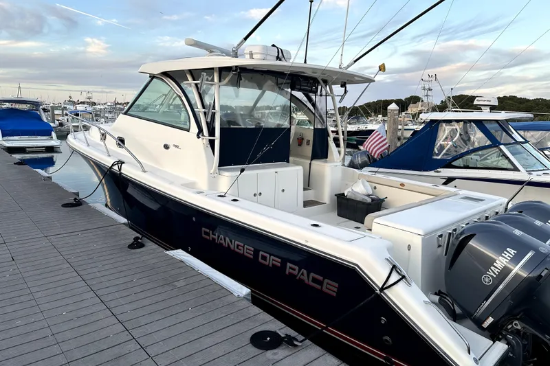 The Image of 2014 PURSUITE 385 boat docked, featuring Yamaha engines and "Change of Pace" name. - 0