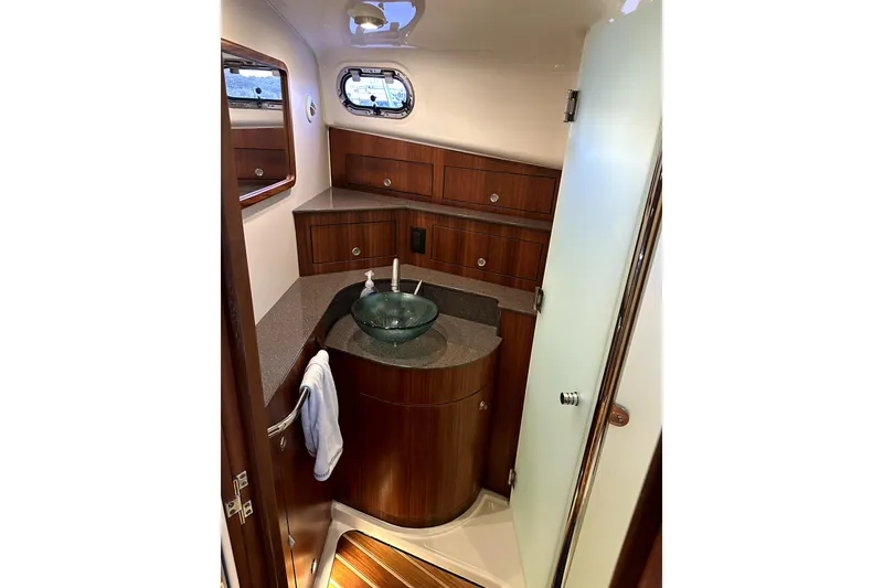 Slide: The Image of Luxurious 2014 PURSUITE 385 yacht bathroom with wooden cabinetry and glass sink. - 11