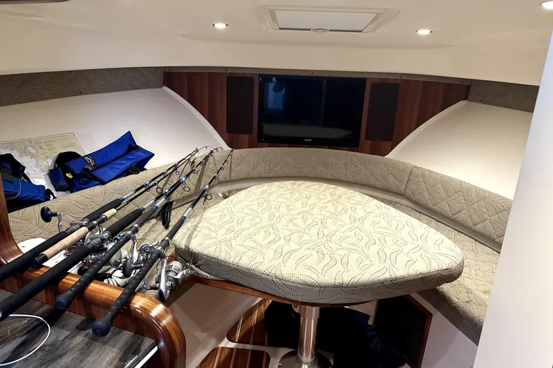 Slide: The Image of Interior of 2014 PURSUITE 385 boat with fishing rods and cushioned seating. - 12