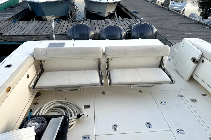 Slide: The Image of 2014 PURSUITE 385 boat interior with white seating and docked engines. - 3