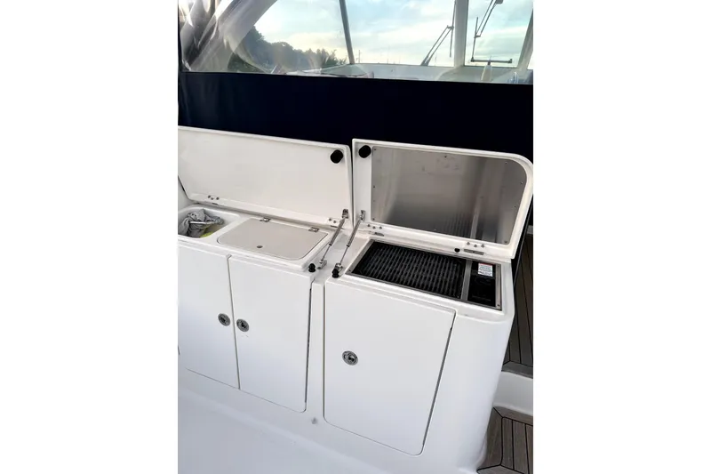 Slide: The Image of Outdoor kitchen area on a 2014 PURSUITE 385 boat, featuring storage and grill. - 4