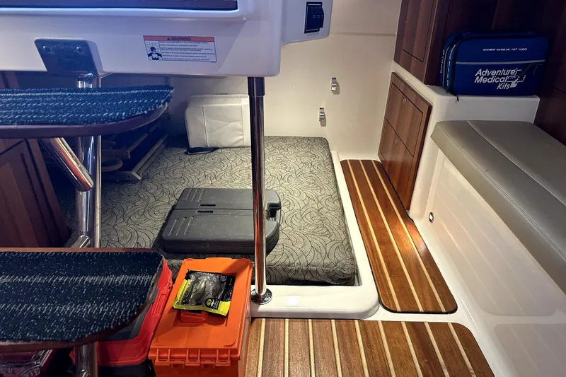 Slide: The Image of Interior of 2014 PURSUITE 385 boat with storage, medical kit, and patterned bedding. - 9