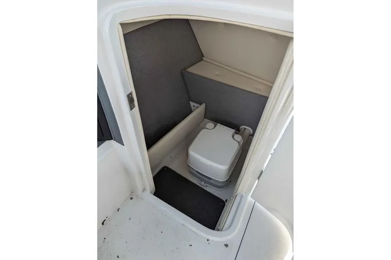 Slide: The Image of 2020 Cobalt 25SC boat interior with compact portable toilet. - 12