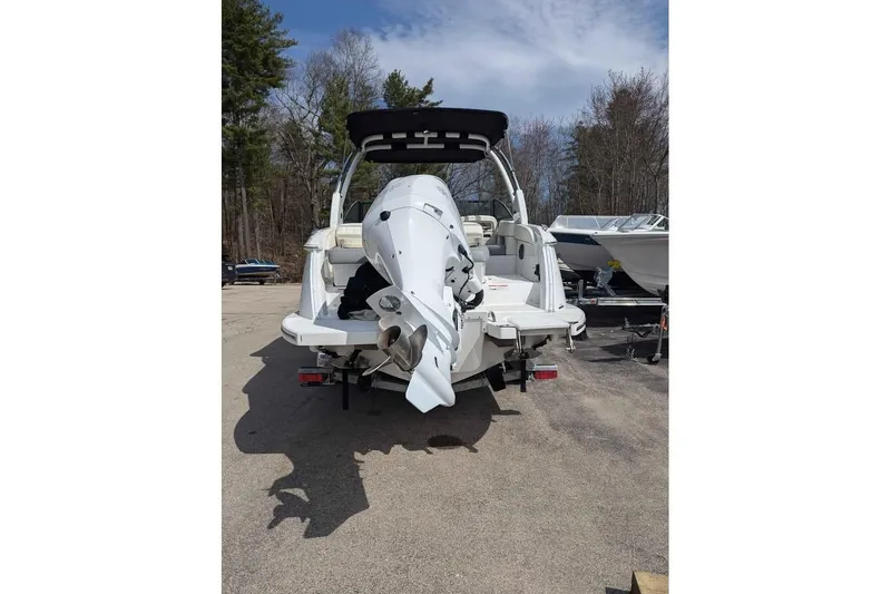 Slide: The Image of 2020 Cobalt 25SC boat with outboard motor, parked outdoors on a sunny day. - 3