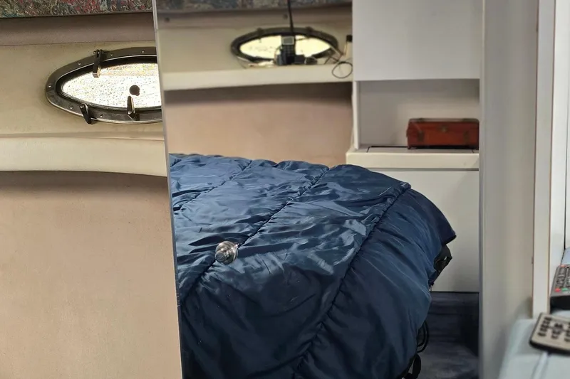 Slide: The Image of Interior of 1995 Formula 34 Performance Cruiser with blue bedding and porthole window. - 26