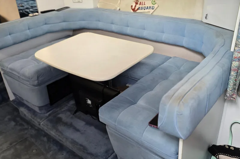 Slide: The Image of 1995 Formula 34 Performance Cruiser interior with blue cushioned seating and dining table. - 27