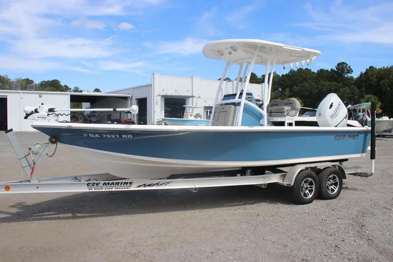 The Image of 2023 Sea Pro 228 Bay boat on trailer, parked outdoors near a marine facility. - 0