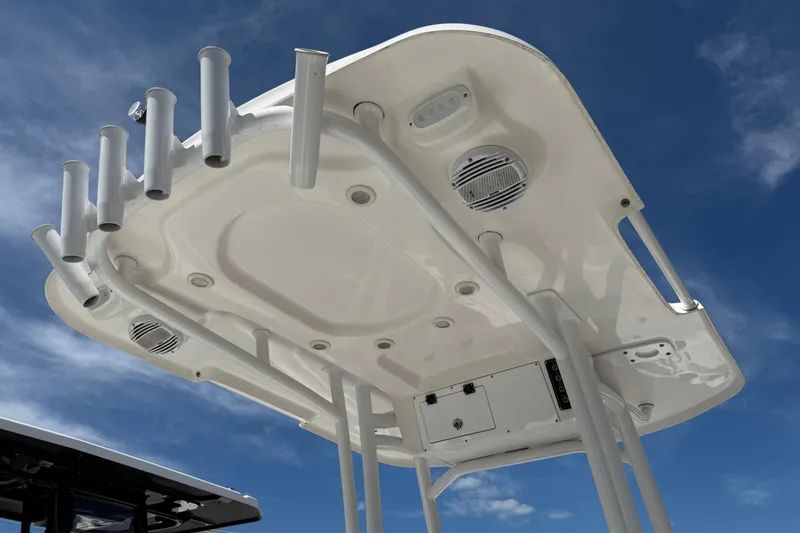 Slide: The Image of 2023 Sea Pro 228 Bay boat T-top with rod holders against blue sky. - 15